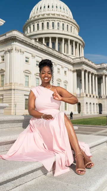Portrait in a pale pink dress with the Capitol in the background