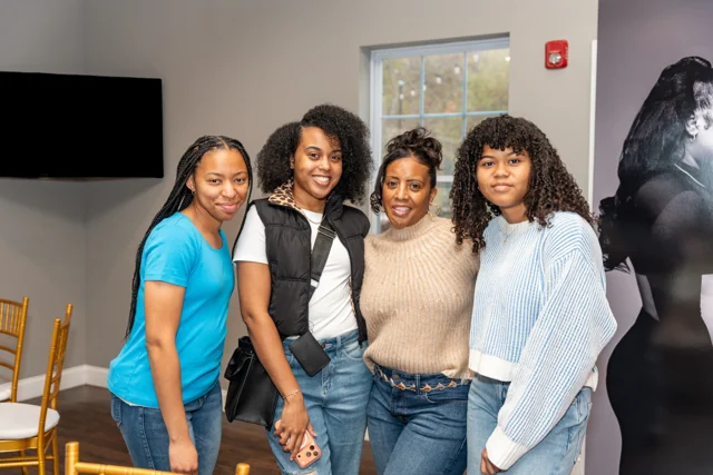 Four guests smiling together at a celebration