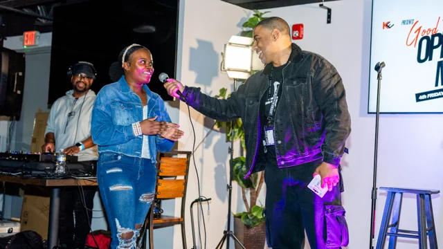 Two performers sharing the microphone at an open mic event