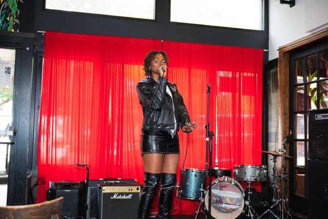 Vocalist in a black leather outfit performing at Out the Box