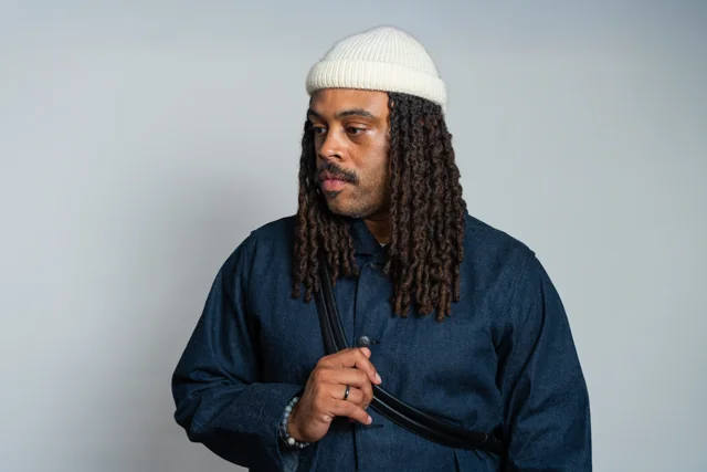 Side profile portrait in a white beanie and navy jacket