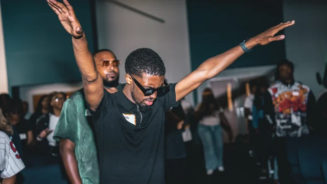 Guests dancing with arms outstretched at a lively celebration