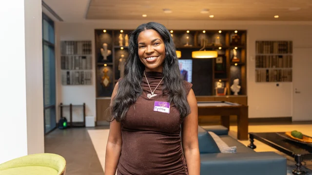 Smiling guest in a brown dress at a social gathering