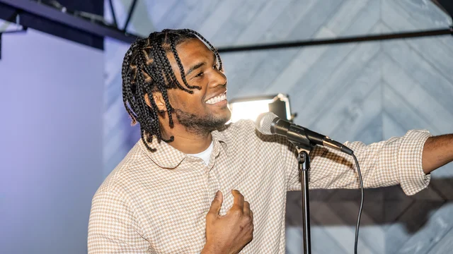Singer reaching toward the audience with a hand over his heart
