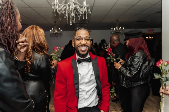 Guest celebrating on the dance floor in a red suit